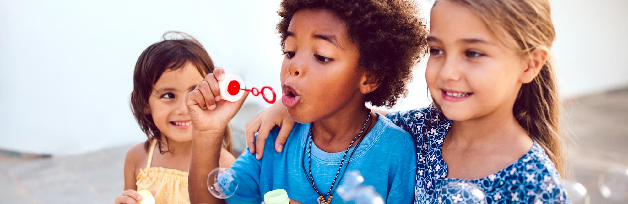 Three children blowing bubbles