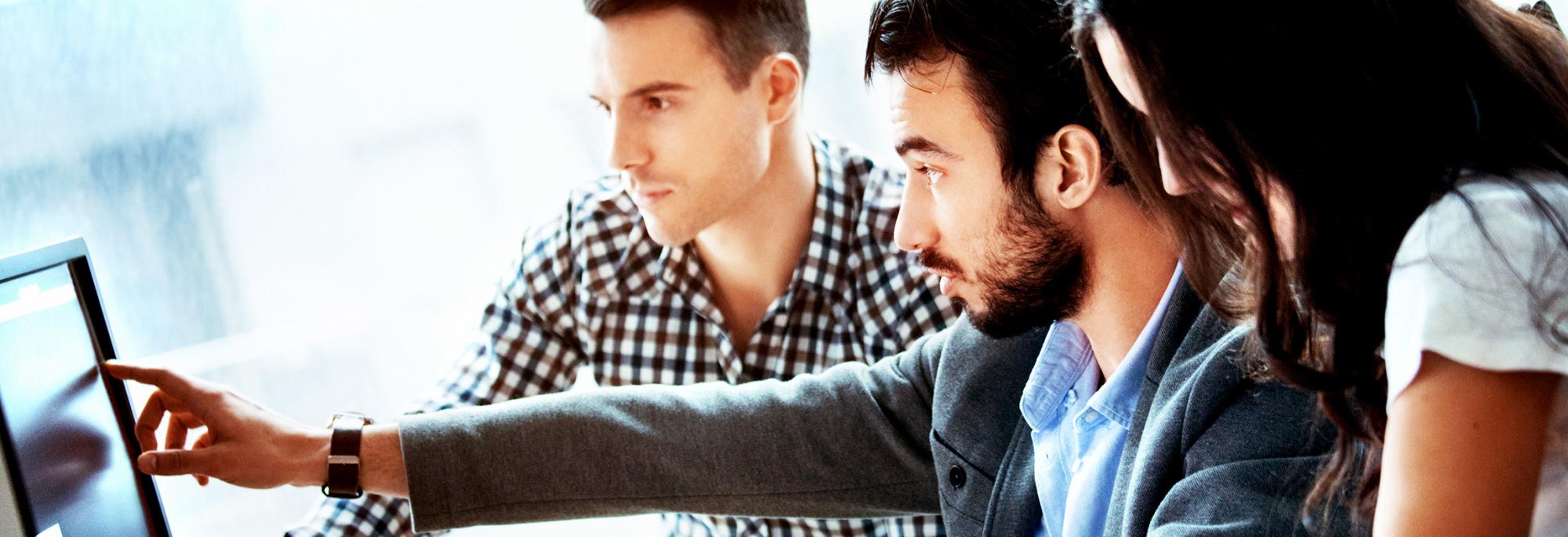 Three people looking at a computer screen