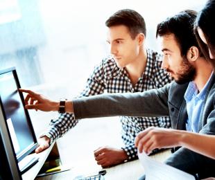 Three people looking at a computer screen